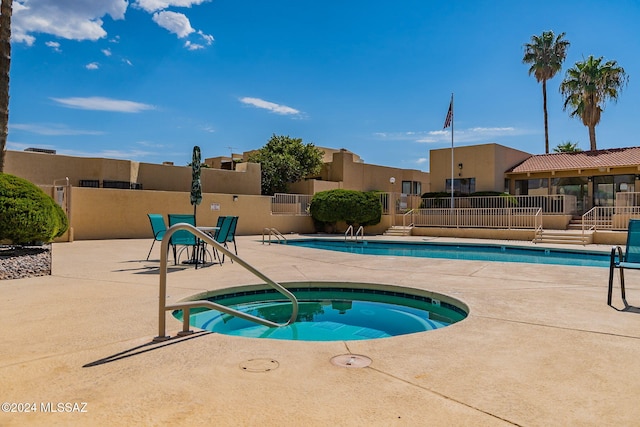 view of swimming pool featuring a hot tub and a patio area