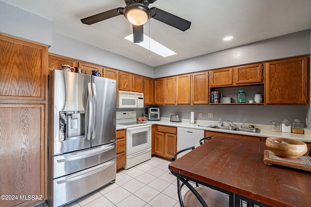 kitchen featuring light tile patterned flooring, ceiling fan, white appliances, and sink