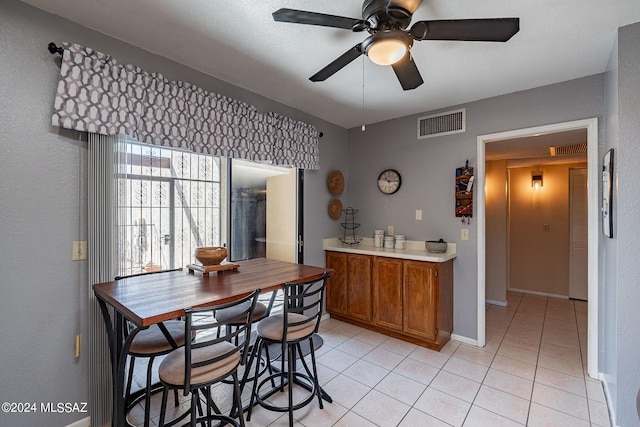 tiled dining area with ceiling fan