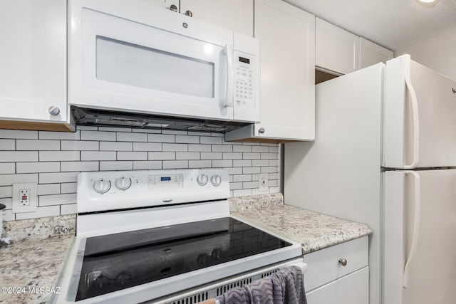 kitchen featuring white cabinets, light stone counters, white appliances, and tasteful backsplash