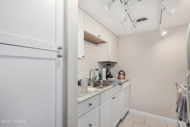 clothes washing area featuring light tile patterned flooring and sink