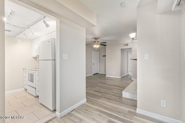 kitchen featuring white appliances, light hardwood / wood-style flooring, ceiling fan, white cabinets, and track lighting