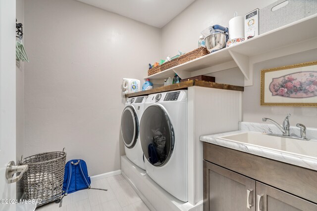 washroom with washer and clothes dryer, cabinets, and sink