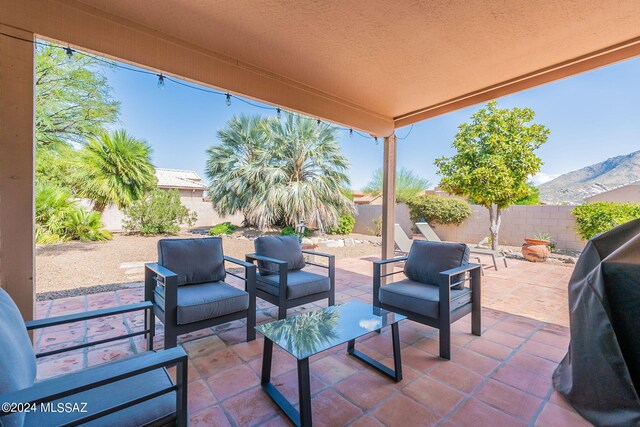view of patio / terrace with an outdoor hangout area, area for grilling, a fenced backyard, and a mountain view