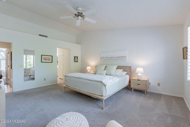 carpeted bedroom with lofted ceiling, visible vents, a ceiling fan, and baseboards