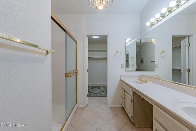 bathroom featuring tile patterned flooring, an enclosed shower, and vanity