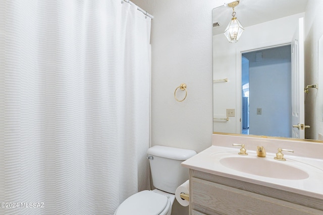 bathroom featuring walk in shower, vanity, and toilet