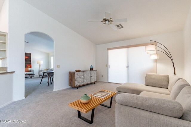 living room with arched walkways, carpet, vaulted ceiling, ceiling fan, and visible vents