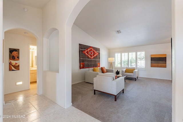 living room featuring light colored carpet and vaulted ceiling