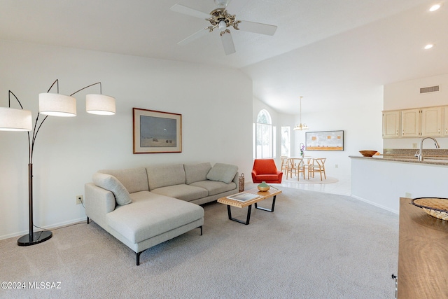 living room featuring lofted ceiling, ceiling fan with notable chandelier, light colored carpet, and sink