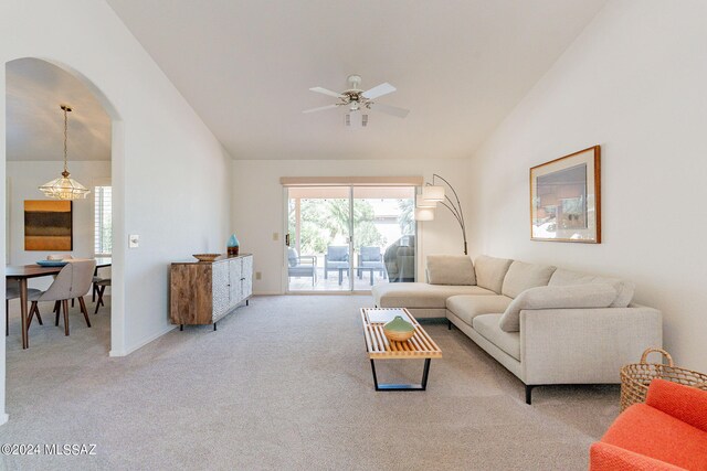 carpeted living area with a ceiling fan, high vaulted ceiling, and arched walkways