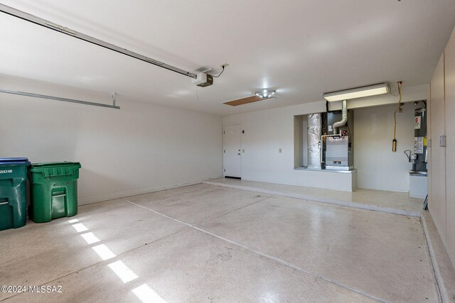 garage with a garage door opener, water heater, and heating unit
