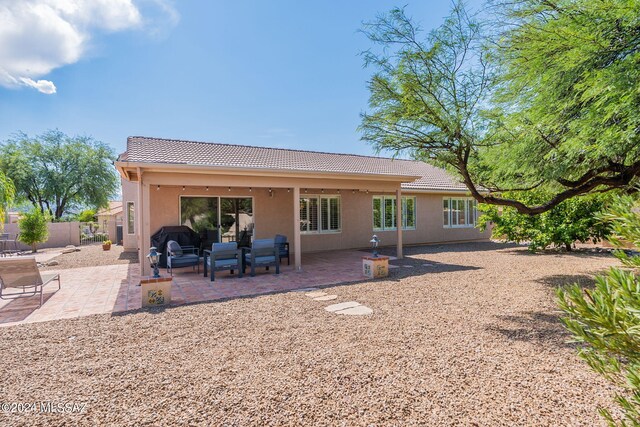 rear view of house featuring fence, stucco siding, a tile roof, and a patio area