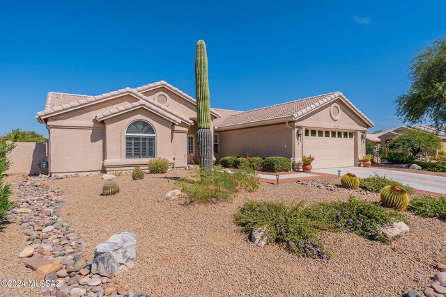 view of front of property with a garage, stucco siding, driveway, and a tiled roof