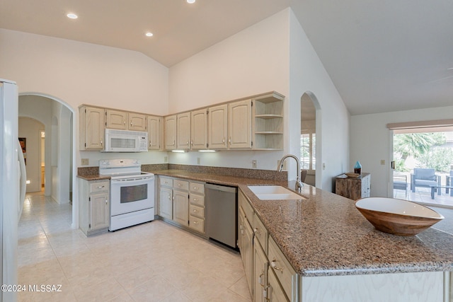 kitchen featuring white appliances, light stone countertops, high vaulted ceiling, and sink