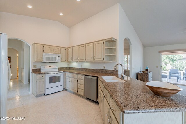 kitchen featuring arched walkways, white appliances, a sink, high vaulted ceiling, and a peninsula