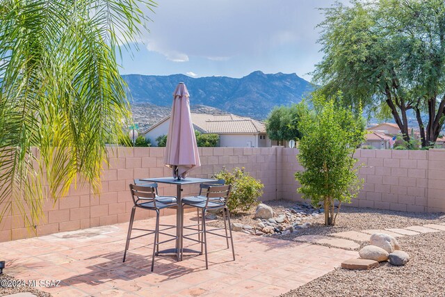 view of patio with a mountain view, a fenced backyard, and outdoor dining area