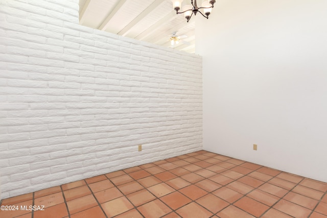 spare room with ceiling fan, light tile patterned floors, and brick wall