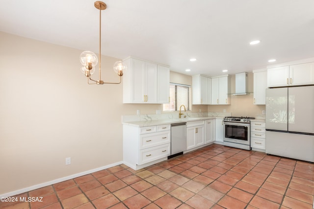 kitchen with white cabinets, sink, pendant lighting, wall chimney range hood, and appliances with stainless steel finishes