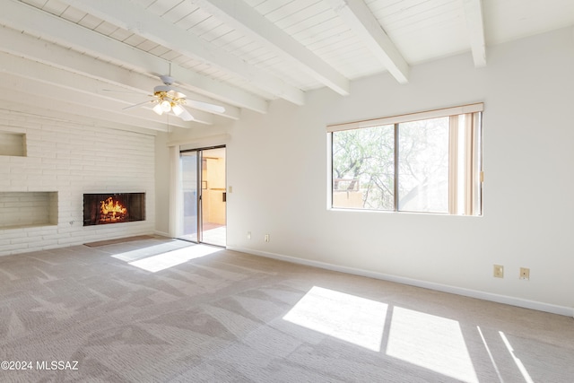 unfurnished living room featuring a fireplace, ceiling fan, beamed ceiling, and light colored carpet