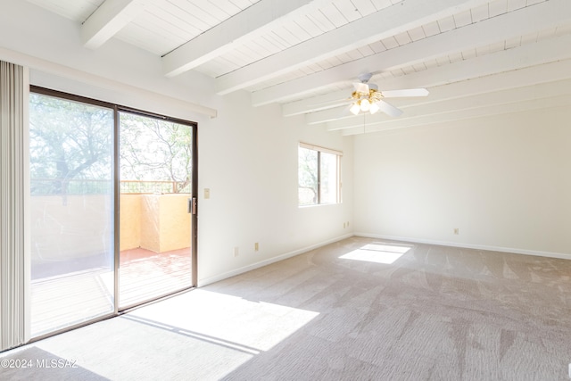 carpeted spare room featuring ceiling fan, beamed ceiling, plenty of natural light, and wood ceiling