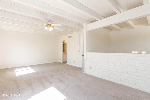 unfurnished room with ceiling fan, beam ceiling, brick wall, and light colored carpet