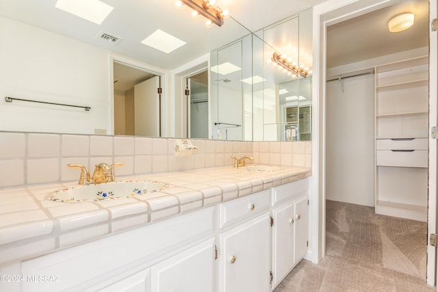 bathroom with tasteful backsplash and vanity