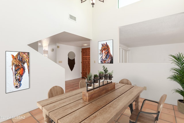 dining space featuring light tile patterned flooring and a high ceiling