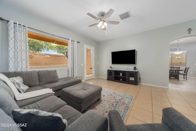 living area with visible vents, arched walkways, a ceiling fan, and tile patterned floors