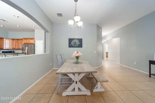 dining area with visible vents, arched walkways, light tile patterned floors, and a notable chandelier