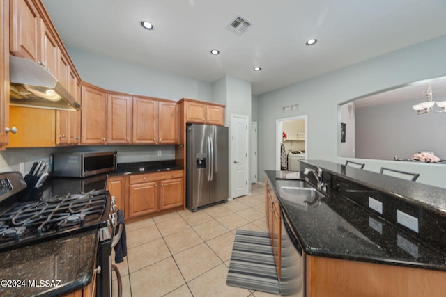 kitchen with visible vents, washing machine and dryer, under cabinet range hood, a sink, and appliances with stainless steel finishes