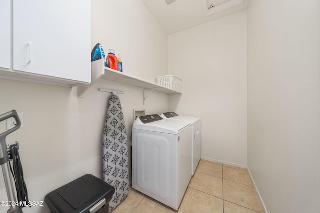 washroom with separate washer and dryer, baseboards, cabinet space, and light tile patterned floors