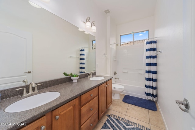 full bath with a sink, tile patterned flooring, toilet, and double vanity