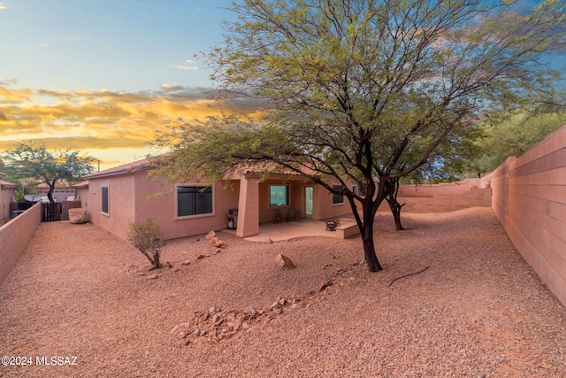 back of property with a fenced backyard, a patio, and stucco siding
