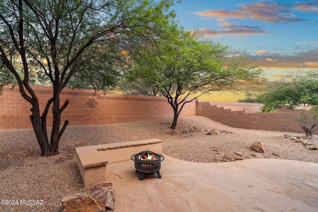 view of yard with a fenced backyard, a patio, and an outdoor fire pit
