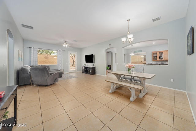 dining room featuring visible vents, arched walkways, ceiling fan with notable chandelier, and light tile patterned floors