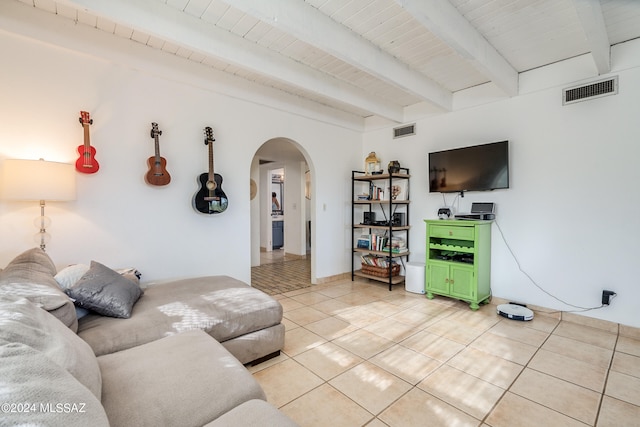 living room featuring beam ceiling, light tile patterned floors, and wooden ceiling