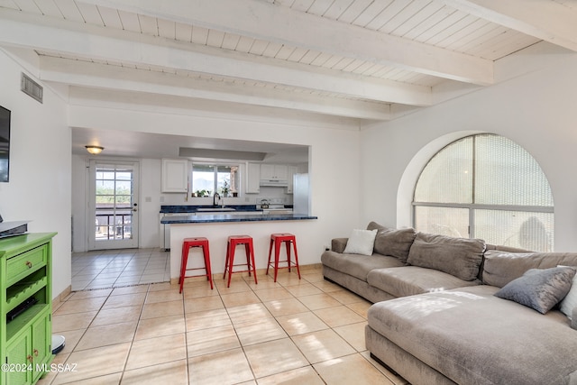 tiled living room with beam ceiling, sink, and wood ceiling