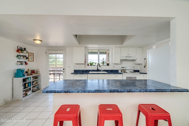 kitchen with kitchen peninsula, a kitchen bar, and white cabinetry