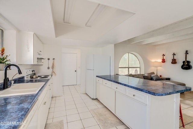 kitchen with sink, light tile patterned flooring, white fridge, white cabinetry, and a kitchen breakfast bar