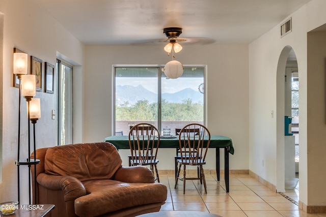 tiled dining area with ceiling fan and a mountain view