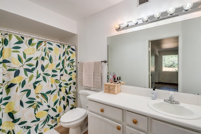 bathroom featuring toilet, vanity, and a shower with shower curtain