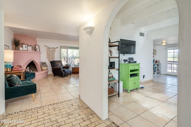 interior space with beamed ceiling and a fireplace