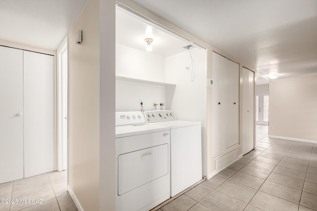 laundry area featuring light tile patterned flooring and washer and clothes dryer