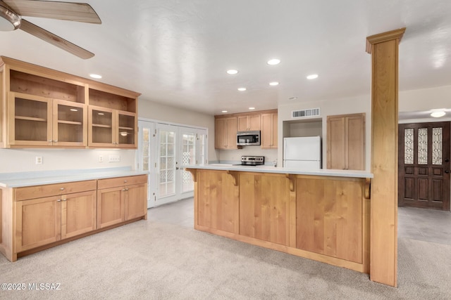 kitchen with light carpet, a breakfast bar, french doors, and appliances with stainless steel finishes