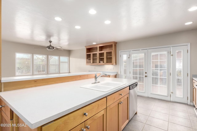 kitchen featuring french doors, sink, light tile patterned floors, dishwasher, and a kitchen island with sink