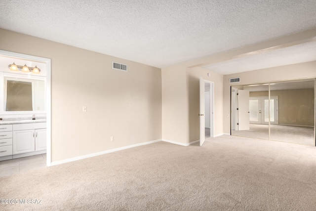 carpeted spare room with a textured ceiling