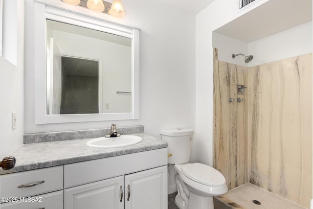 bathroom featuring walk in shower, vanity, and toilet