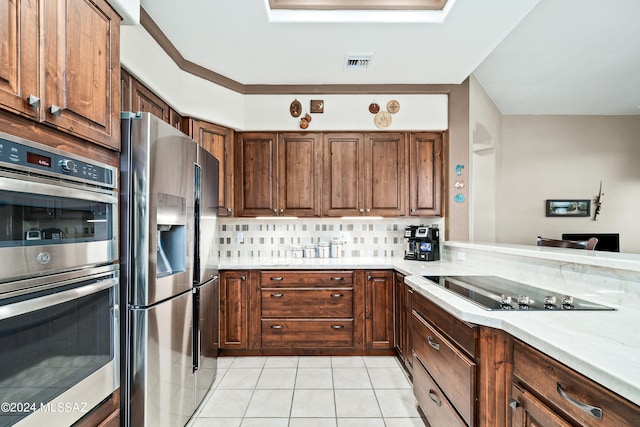 kitchen with tasteful backsplash, light tile patterned flooring, and stainless steel appliances