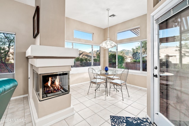 tiled dining space featuring a multi sided fireplace